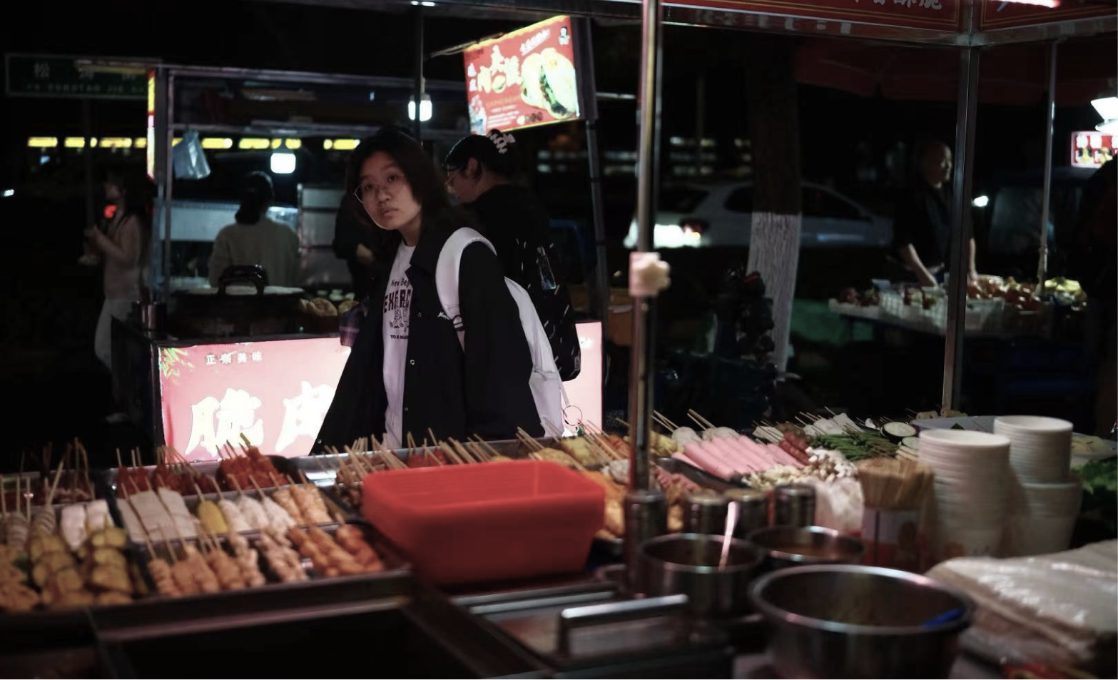 A customer observing a night-market food stall during testing